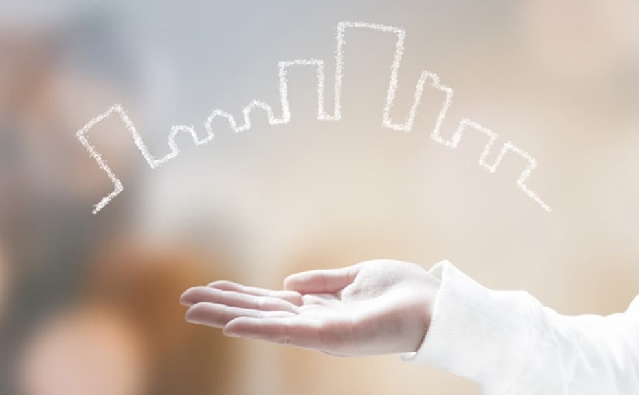 手のひらの上に街のイラストが浮かんでいるイメージ写真